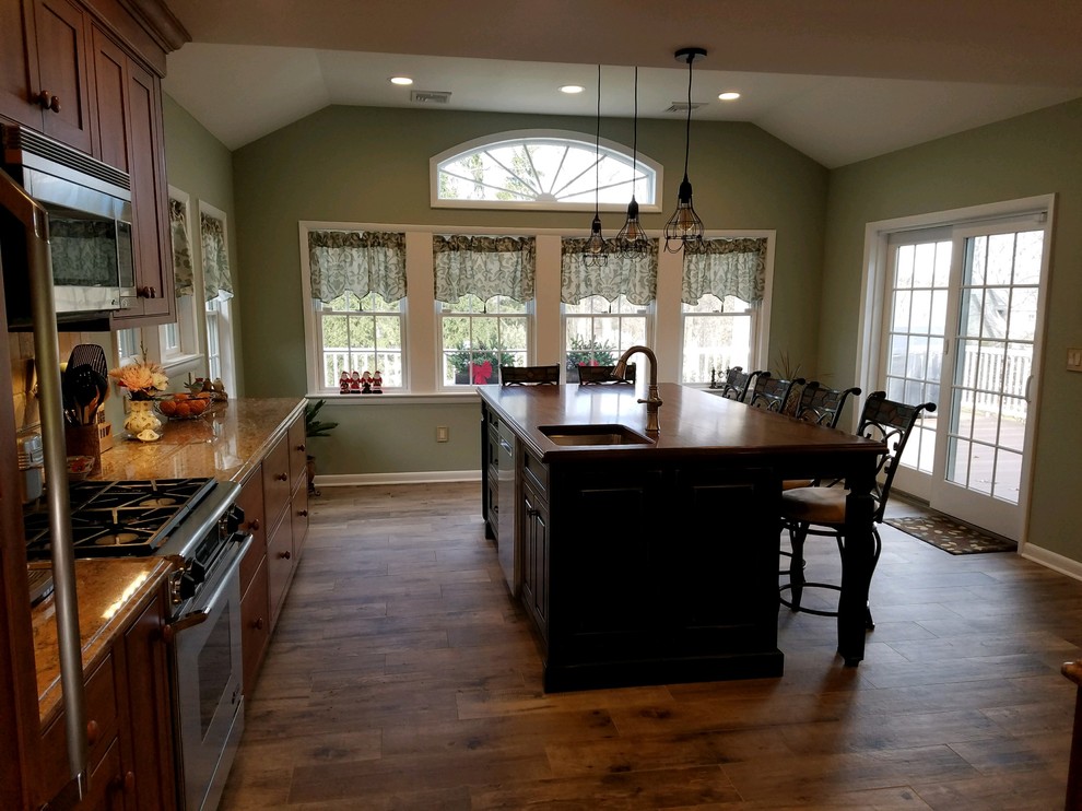 Foto på ett mellanstort vintage kök, med luckor med infälld panel, skåp i mellenmörkt trä, träbänkskiva, rostfria vitvaror, mellanmörkt trägolv och en köksö