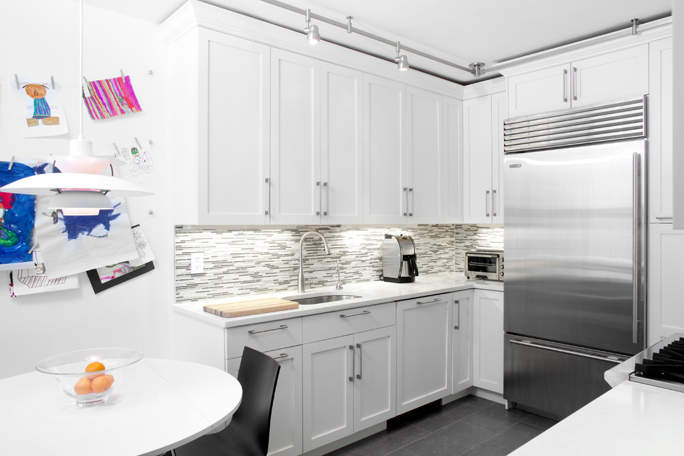 Moderne Wohnküche in U-Form mit Unterbauwaschbecken, Schrankfronten im Shaker-Stil, weißen Schränken, Küchenrückwand in Grau, Rückwand aus Stäbchenfliesen und Küchengeräten aus Edelstahl in New York