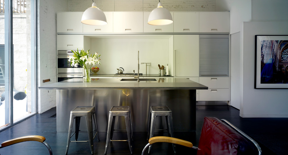 Foto di una piccola cucina minimalista con lavello sottopiano, ante lisce, ante bianche, top in acciaio inossidabile, elettrodomestici in acciaio inossidabile e parquet scuro