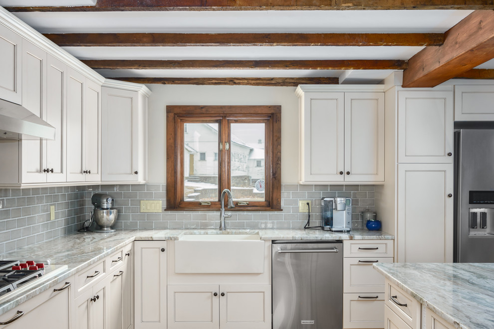 Large farmhouse l-shaped medium tone wood floor and brown floor eat-in kitchen photo in Boston with a farmhouse sink, recessed-panel cabinets, white cabinets, granite countertops, gray backsplash, ceramic backsplash, stainless steel appliances, an island and gray countertops