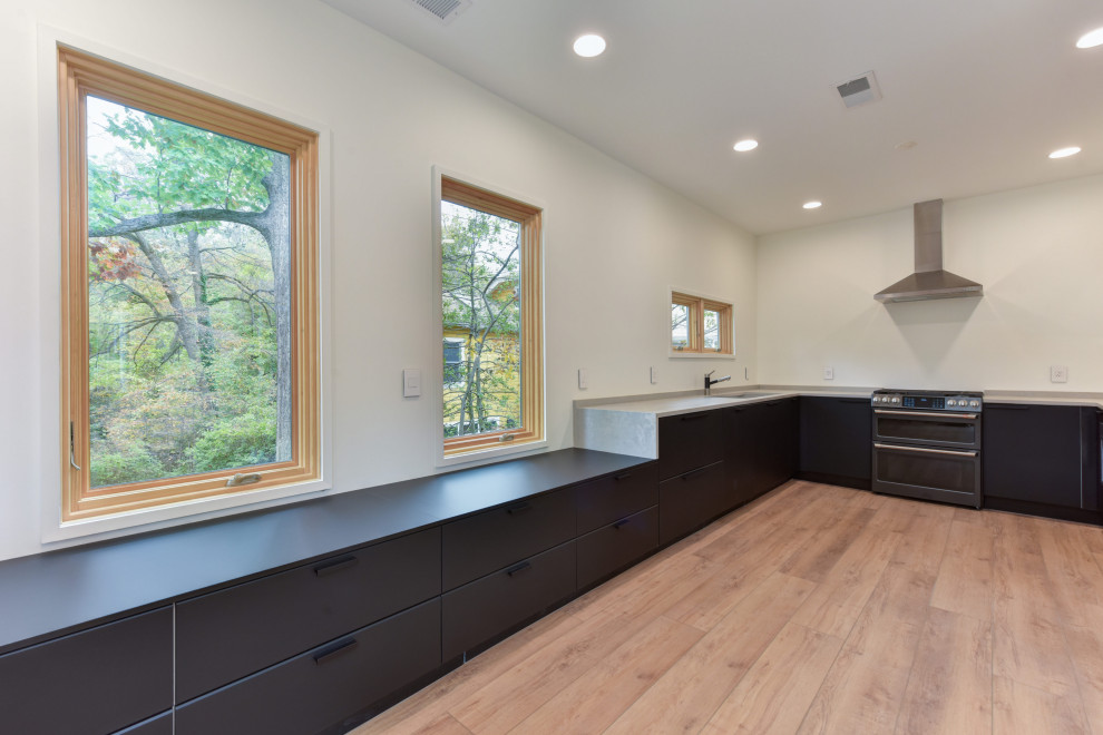 Medium sized modern u-shaped enclosed kitchen in DC Metro with a submerged sink, shaker cabinets, black cabinets, black appliances, medium hardwood flooring, no island, brown floors and white worktops.