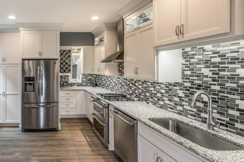 Exempel på ett litet klassiskt grå linjärt grått kök, med en nedsänkt diskho, släta luckor, vita skåp, granitbänkskiva, flerfärgad stänkskydd, stänkskydd i keramik, rostfria vitvaror, vinylgolv och brunt golv
