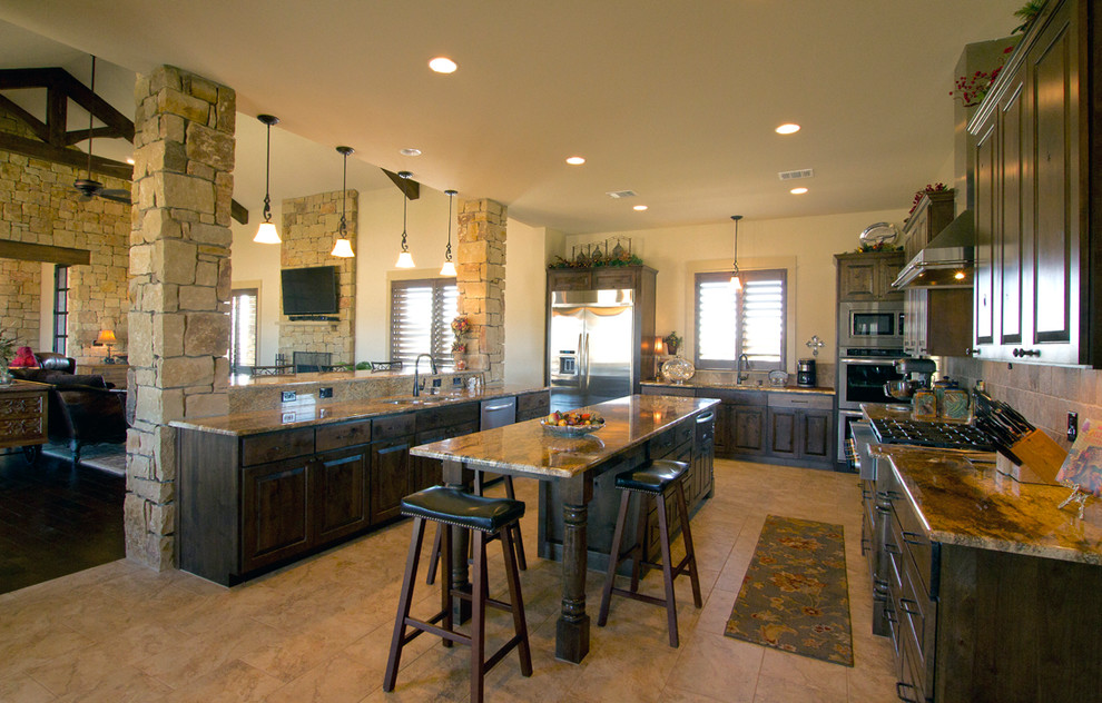 Example of a large classic u-shaped ceramic tile and beige floor open concept kitchen design in Austin with an undermount sink, raised-panel cabinets, dark wood cabinets, granite countertops, beige backsplash, ceramic backsplash, stainless steel appliances and an island