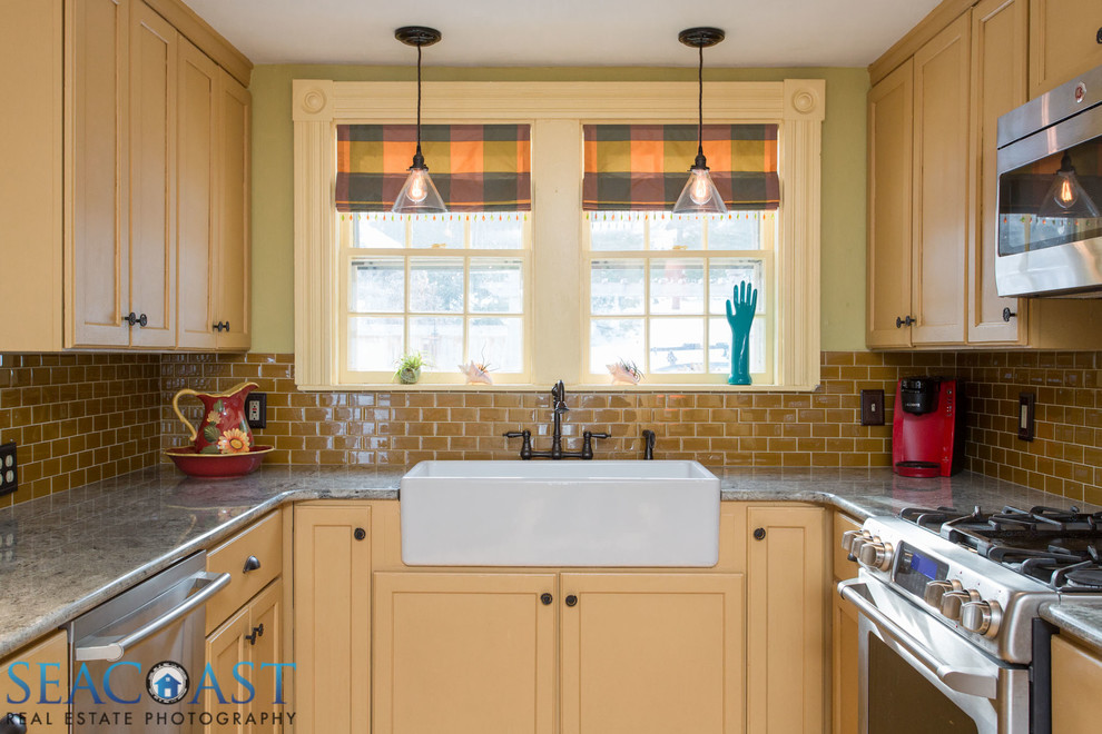 Exempel på ett avskilt, litet lantligt u-kök, med en rustik diskho, luckor med upphöjd panel, beige skåp, granitbänkskiva, beige stänkskydd, stänkskydd i glaskakel, rostfria vitvaror och mellanmörkt trägolv