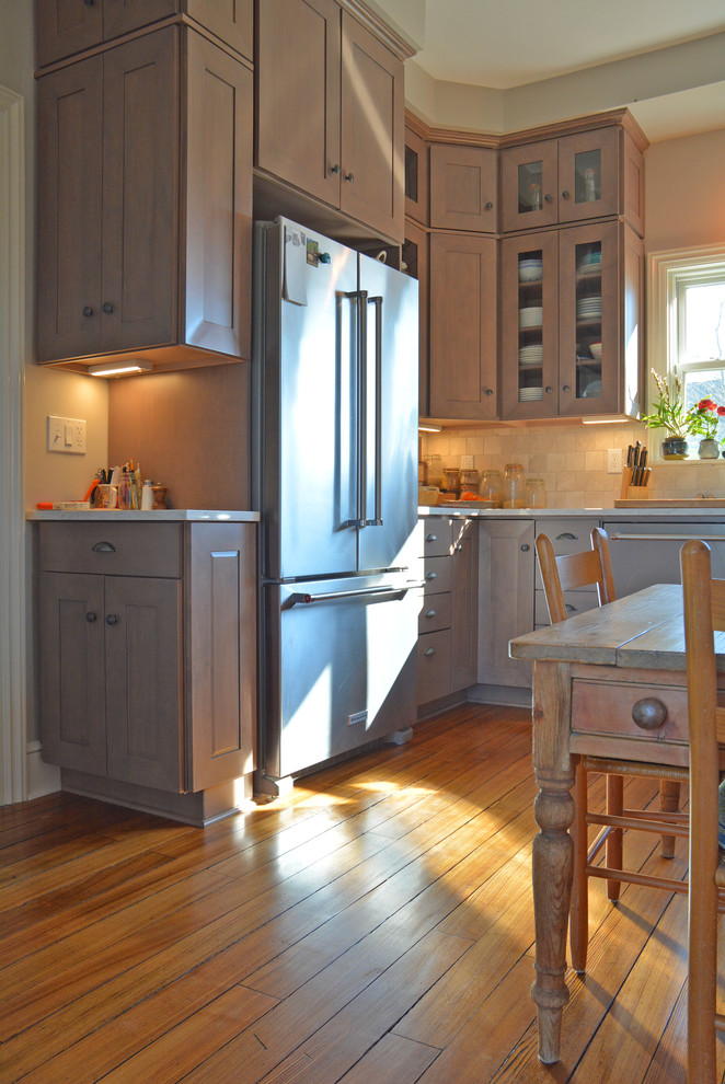 Eat-in kitchen - mid-sized country u-shaped light wood floor and brown floor eat-in kitchen idea in Other with a farmhouse sink, flat-panel cabinets, medium tone wood cabinets, quartz countertops, beige backsplash, ceramic backsplash, stainless steel appliances and no island