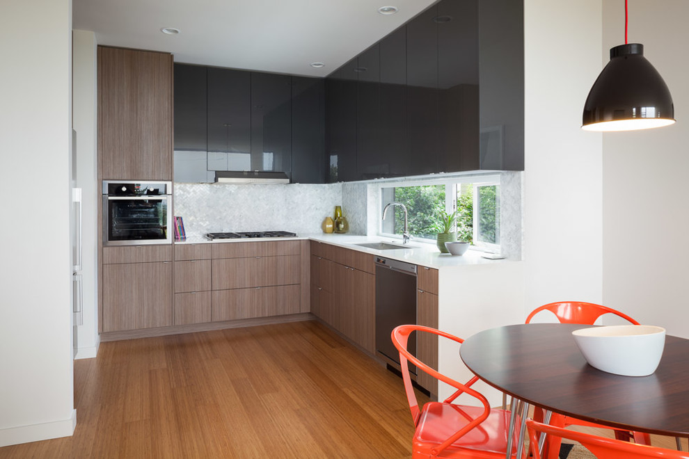 Aménagement d'une cuisine américaine bicolore contemporaine en bois brun avec un placard à porte plane.