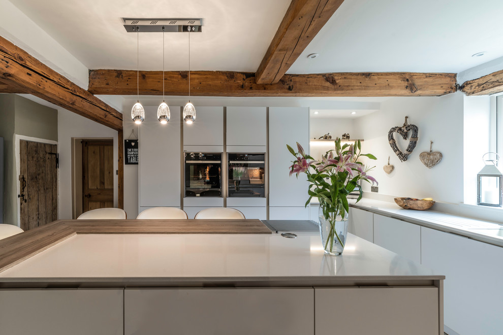 Country kitchen in Cheshire with flat-panel cabinets, white cabinets and a breakfast bar.
