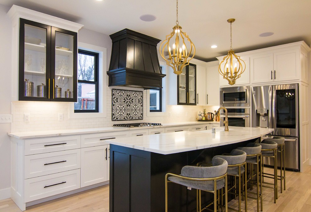 Mid-sized tuscan l-shaped light wood floor and beige floor eat-in kitchen photo in Minneapolis with a farmhouse sink, white backsplash, subway tile backsplash, stainless steel appliances, an island, white countertops, quartz countertops and shaker cabinets