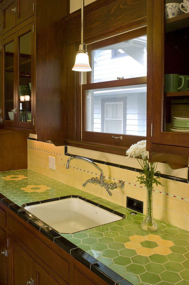 Example of a small arts and crafts single-wall enclosed kitchen design in Portland with shaker cabinets, dark wood cabinets, tile countertops, yellow backsplash, ceramic backsplash, white appliances and no island