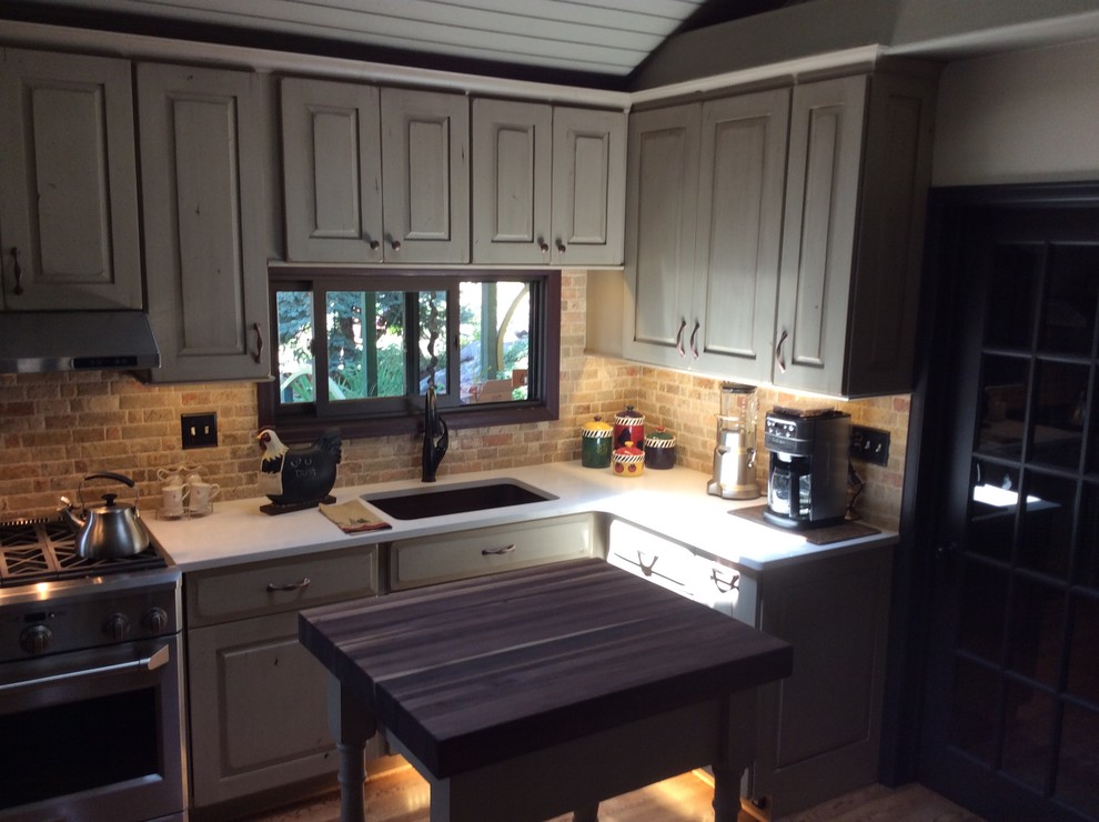 Foto på ett litet rustikt kök, med en undermonterad diskho, luckor med upphöjd panel, skåp i slitet trä, rostfria vitvaror, ljust trägolv, en köksö, bänkskiva i koppar, beige stänkskydd och stänkskydd i stenkakel