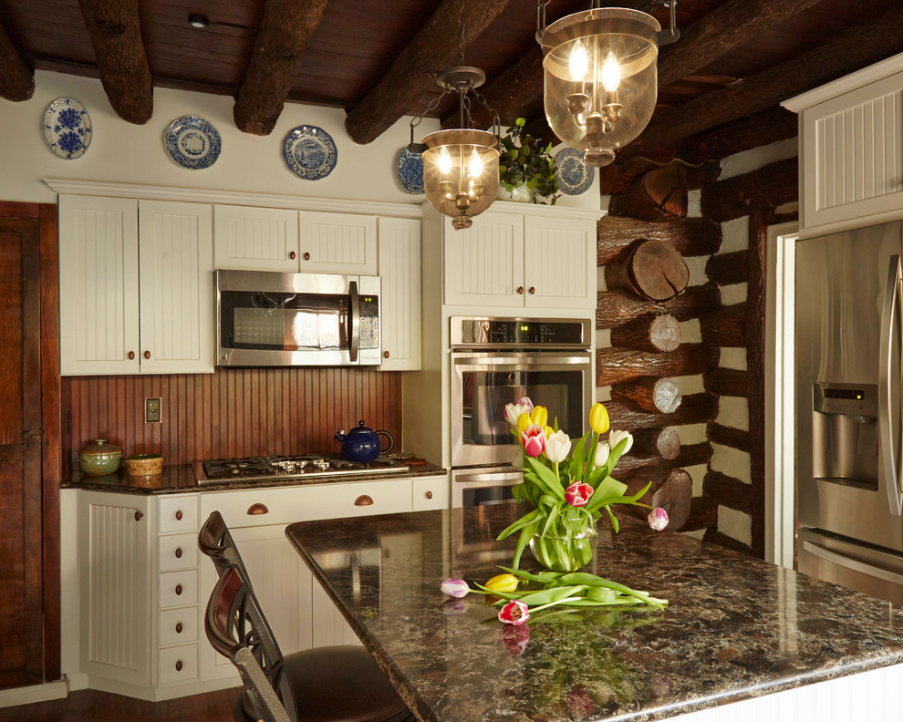 Exempel på ett avskilt, mellanstort rustikt l-kök, med en rustik diskho, luckor med glaspanel, vita skåp, granitbänkskiva, rostfria vitvaror, mellanmörkt trägolv, en köksö, brunt stänkskydd, stänkskydd i trä och brunt golv