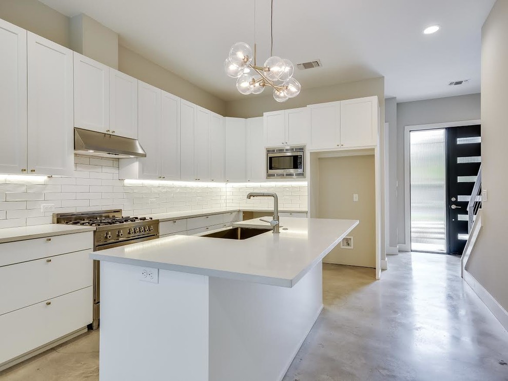 Medium sized traditional l-shaped enclosed kitchen in Orange County with a belfast sink, shaker cabinets, white cabinets, composite countertops, white splashback, porcelain splashback, stainless steel appliances, ceramic flooring and multiple islands.