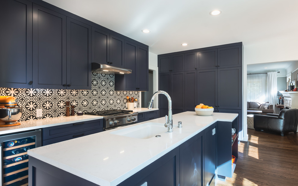 Traditional kitchen in Sacramento with a submerged sink, shaker cabinets, blue cabinets, engineered stone countertops, multi-coloured splashback, cement tile splashback, stainless steel appliances, medium hardwood flooring, an island, brown floors and white worktops.