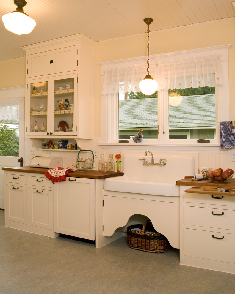 Пример оригинального дизайна: кухня в стиле кантри с с полувстраиваемой мойкой (с передним бортиком) и деревянной столешницей