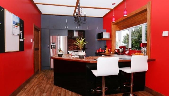 Ejemplo de cocina rústica con puertas de armario grises, encimera de madera, electrodomésticos de acero inoxidable y suelo vinílico