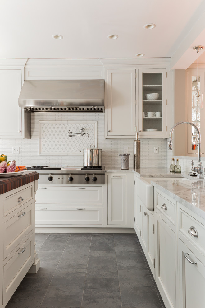 Klassische Küche mit Landhausspüle, Schrankfronten mit vertiefter Füllung, weißen Schränken, Küchenrückwand in Weiß, Küchengeräten aus Edelstahl, Schieferboden und grauem Boden in Boston