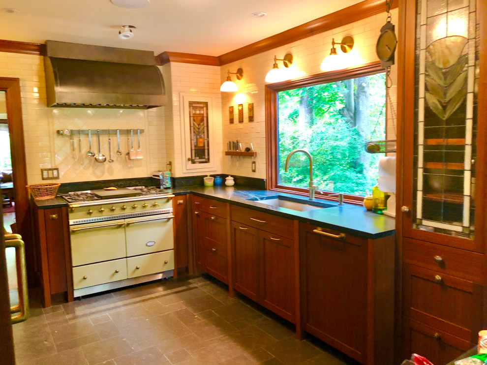 Enclosed kitchen - mid-sized craftsman l-shaped limestone floor and black floor enclosed kitchen idea in Seattle with an undermount sink, shaker cabinets, dark wood cabinets, soapstone countertops, white backsplash, subway tile backsplash, colored appliances, no island and black countertops