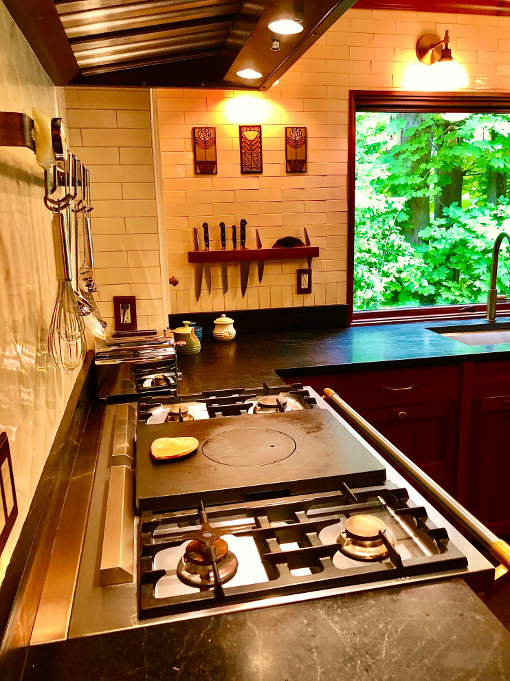Enclosed kitchen - mid-sized craftsman l-shaped limestone floor and black floor enclosed kitchen idea in Seattle with an undermount sink, shaker cabinets, dark wood cabinets, soapstone countertops, white backsplash, subway tile backsplash, colored appliances, no island and black countertops
