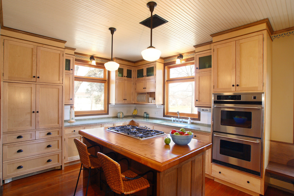 Inspiration for a craftsman l-shaped medium tone wood floor enclosed kitchen remodel in Minneapolis with an undermount sink, shaker cabinets, light wood cabinets, granite countertops, white backsplash, subway tile backsplash, stainless steel appliances and an island