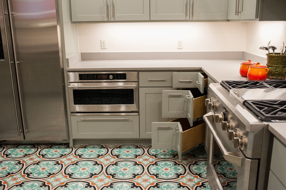 Inspiration for a mid-sized mediterranean cement tile floor enclosed kitchen remodel in Austin with a single-bowl sink, shaker cabinets, quartz countertops, green cabinets, beige backsplash, stainless steel appliances and no island