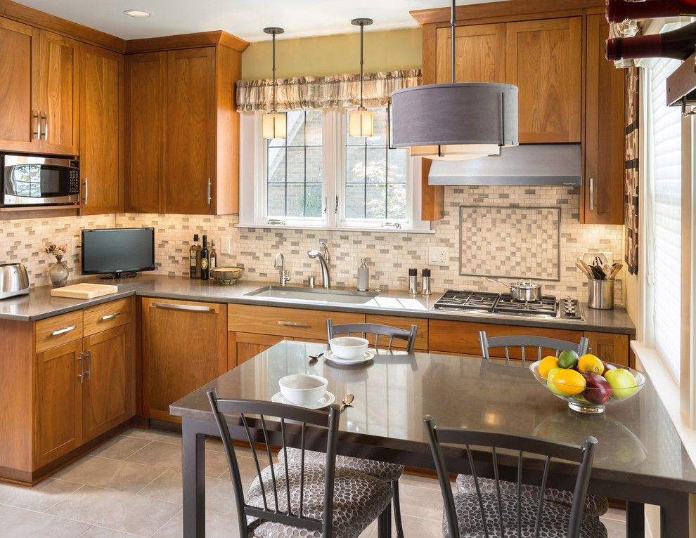 Example of a mid-sized transitional l-shaped porcelain tile enclosed kitchen design in Milwaukee with an undermount sink, recessed-panel cabinets, medium tone wood cabinets, quartz countertops, multicolored backsplash and stainless steel appliances