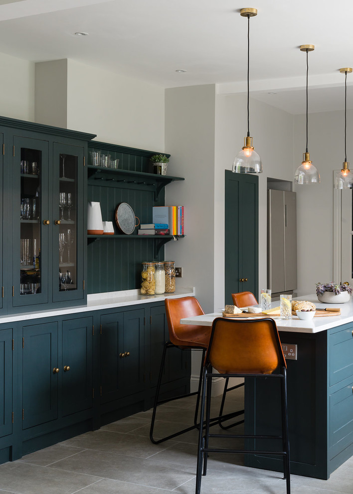 Zweizeilige Klassische Wohnküche mit Schrankfronten im Shaker-Stil, grünen Schränken, Küchenrückwand in Grün, Rückwand aus Holz, Kücheninsel, grauem Boden und weißer Arbeitsplatte in London