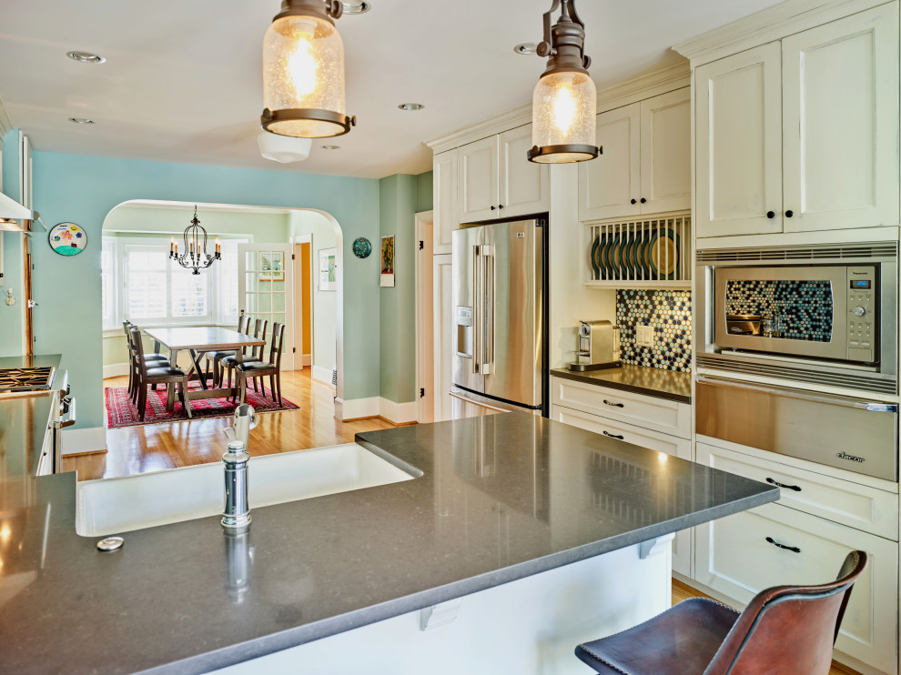 Foto på ett mellanstort amerikanskt grå kök, med en rustik diskho, skåp i shakerstil, skåp i slitet trä, bänkskiva i kvarts, blått stänkskydd, stänkskydd i mosaik, rostfria vitvaror, mellanmörkt trägolv och en halv köksö
