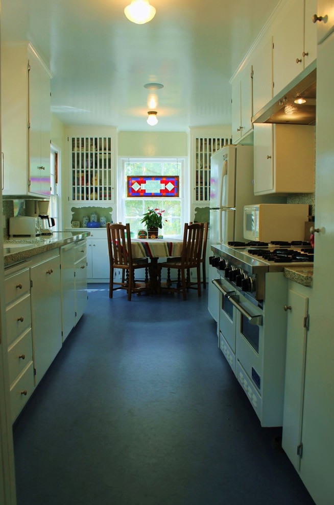 Example of a mid-sized island style galley linoleum floor enclosed kitchen design in Los Angeles with an undermount sink, white cabinets, quartz countertops, multicolored backsplash, white appliances, no island and flat-panel cabinets