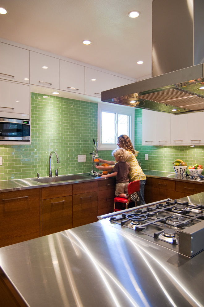 Minimalist kitchen photo in Other with an integrated sink, stainless steel countertops, green backsplash and subway tile backsplash