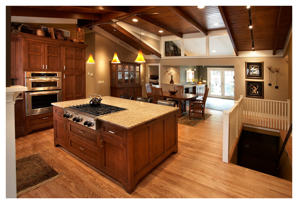 Mid-sized arts and crafts l-shaped light wood floor eat-in kitchen photo in Minneapolis with an undermount sink, flat-panel cabinets, dark wood cabinets, quartz countertops, metallic backsplash, metal backsplash, stainless steel appliances and an island