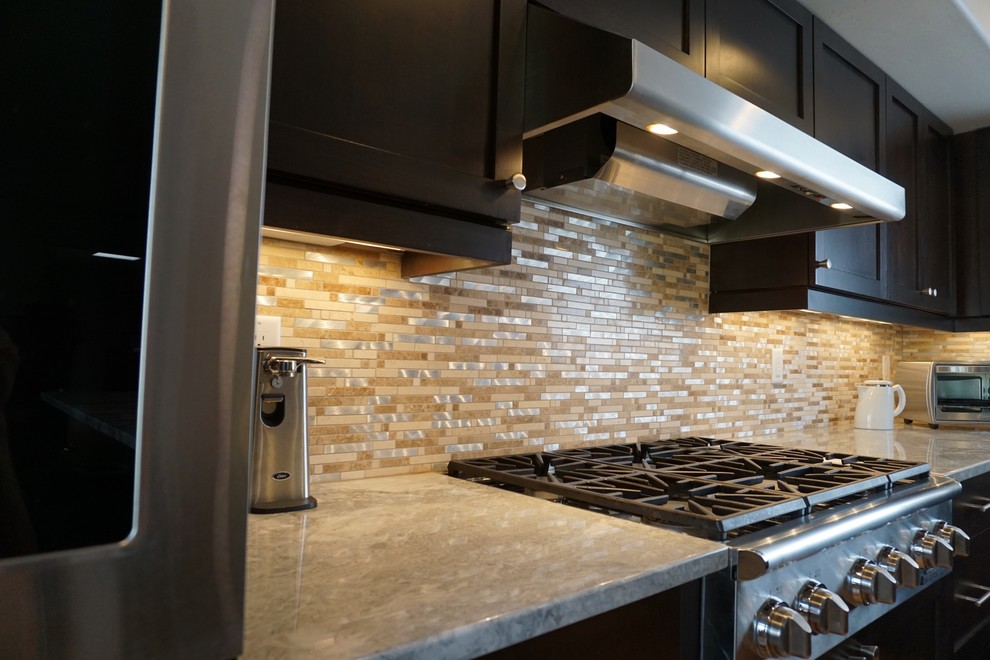 Example of a trendy galley bamboo floor eat-in kitchen design in Phoenix with an undermount sink, shaker cabinets, dark wood cabinets, granite countertops, beige backsplash, glass sheet backsplash, stainless steel appliances and an island