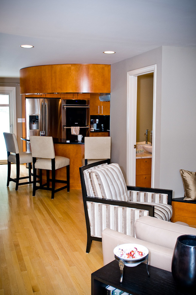 Example of a mid-sized trendy u-shaped light wood floor eat-in kitchen design in Boston with flat-panel cabinets, medium tone wood cabinets, black backsplash, stainless steel appliances, a peninsula and quartz countertops