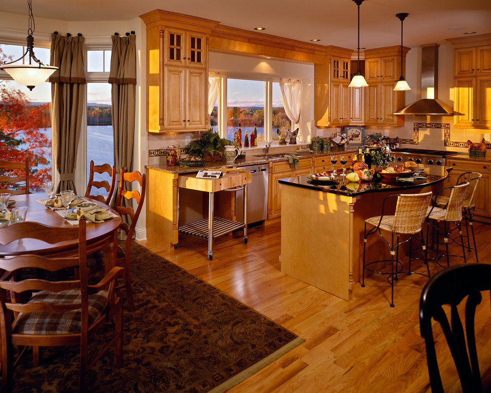 Inredning av ett klassiskt kök och matrum, med luckor med upphöjd panel, skåp i mellenmörkt trä, flerfärgad stänkskydd och rostfria vitvaror