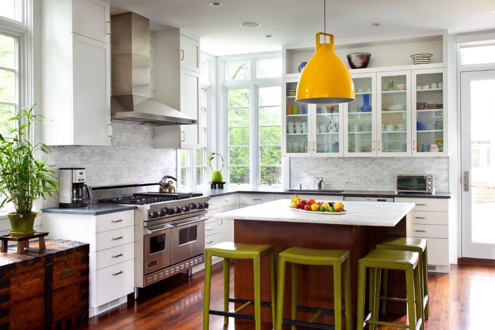 Exempel på ett klassiskt l-kök, med luckor med glaspanel, vita skåp, vitt stänkskydd, stänkskydd i marmor, rostfria vitvaror, mellanmörkt trägolv, en köksö och orange golv