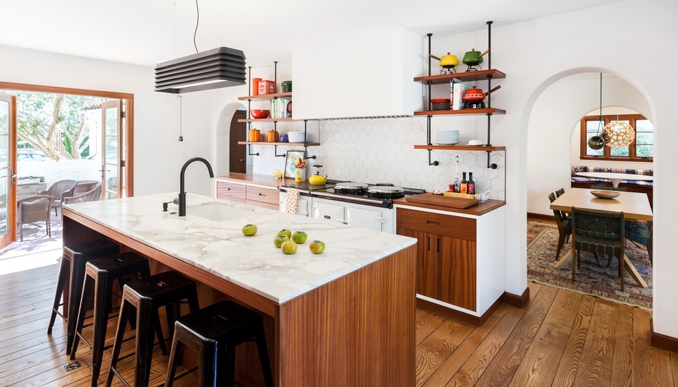 Modelo de cocina mediterránea con fregadero bajoencimera, armarios abiertos, salpicadero blanco, suelo de madera en tonos medios, una isla y electrodomésticos blancos