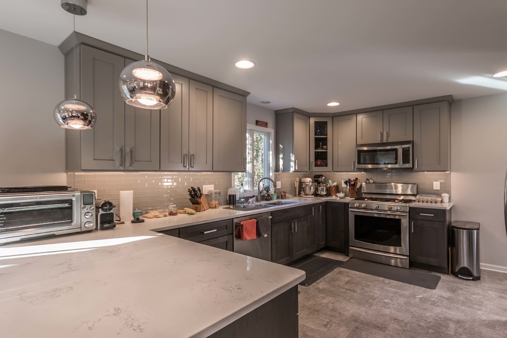 Mid-sized transitional u-shaped porcelain tile and gray floor eat-in kitchen photo in Chicago with a single-bowl sink, shaker cabinets, gray cabinets, quartz countertops, gray backsplash, glass tile backsplash, stainless steel appliances, a peninsula and white countertops