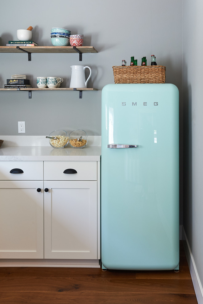 Inspiration for a mid-sized country u-shaped medium tone wood floor and brown floor enclosed kitchen remodel in San Diego with an undermount sink, shaker cabinets, white cabinets, quartz countertops, white backsplash, colored appliances and an island