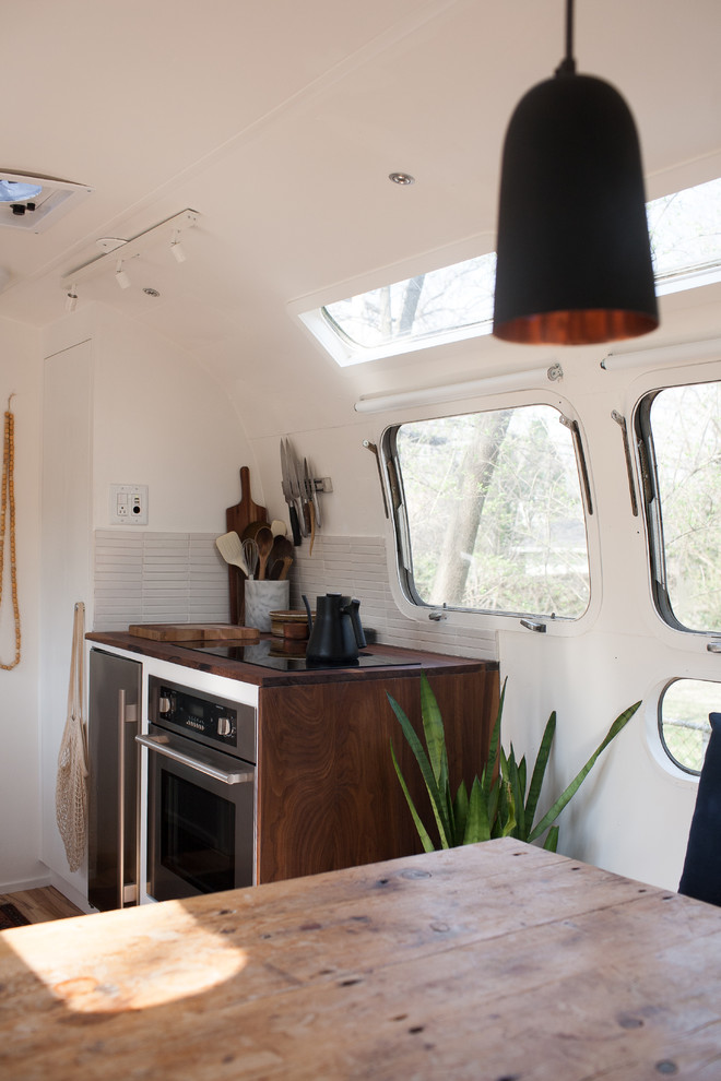 Photo of a modern kitchen in San Francisco with white cabinets, wood worktops, white splashback and ceramic splashback.