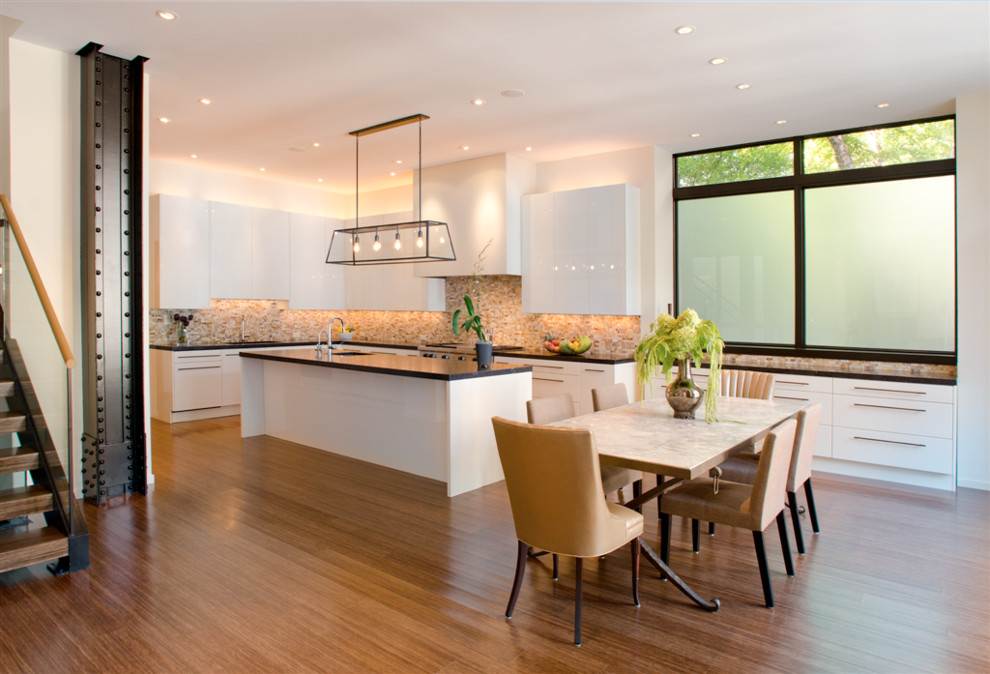 Esempio di una grande cucina design con lavello da incasso, ante lisce, ante bianche, paraspruzzi marrone, pavimento in bambù, paraspruzzi con piastrelle di vetro e top in granito