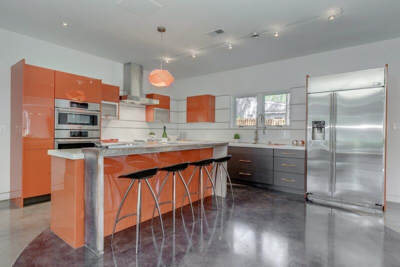 Foto på ett stort funkis linjärt kök med öppen planlösning, med släta luckor, orange skåp, bänkskiva i koppar, vitt stänkskydd, glaspanel som stänkskydd, rostfria vitvaror, betonggolv och en köksö