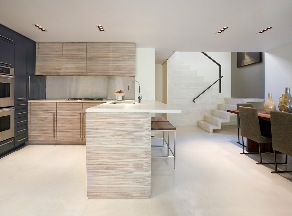 Esempio di una grande cucina design con lavello sottopiano, ante lisce, ante in legno chiaro, paraspruzzi a effetto metallico, elettrodomestici in acciaio inossidabile e pavimento in cemento