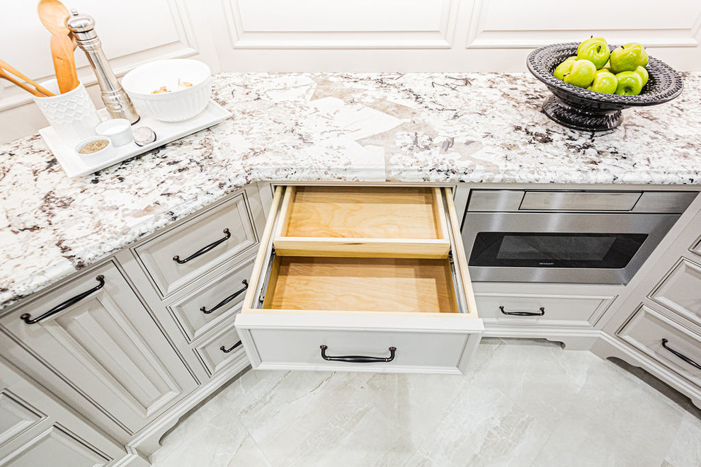 Inspiration for a large transitional porcelain tile and beige floor kitchen remodel in Other with a farmhouse sink, beaded inset cabinets, gray cabinets, granite countertops, porcelain backsplash, stainless steel appliances, an island and beige countertops