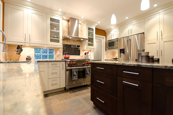 Example of a classic u-shaped eat-in kitchen design in Vancouver with an undermount sink, shaker cabinets, dark wood cabinets, granite countertops, beige backsplash, stone tile backsplash and stainless steel appliances