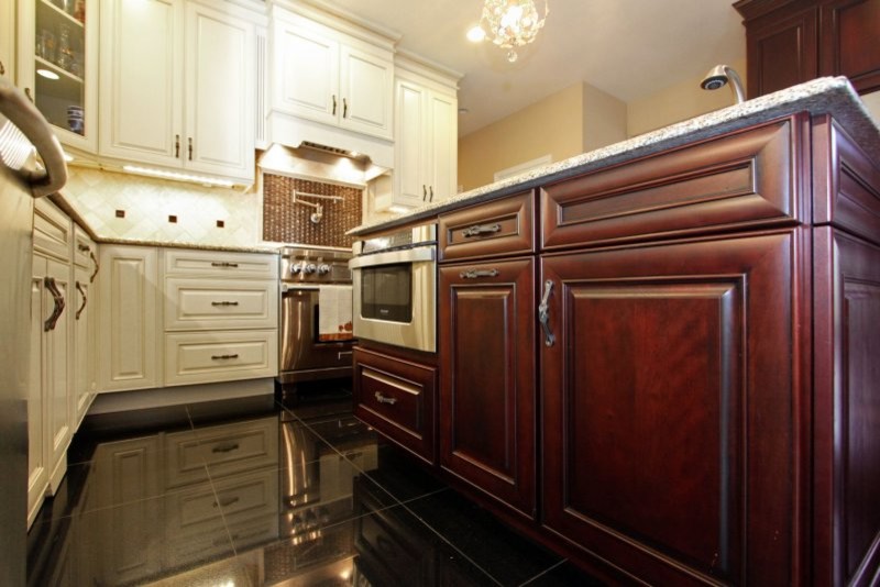 Example of a mid-sized classic marble floor kitchen pantry design in New York with a single-bowl sink, raised-panel cabinets, white cabinets, granite countertops, beige backsplash, stone tile backsplash, stainless steel appliances and an island