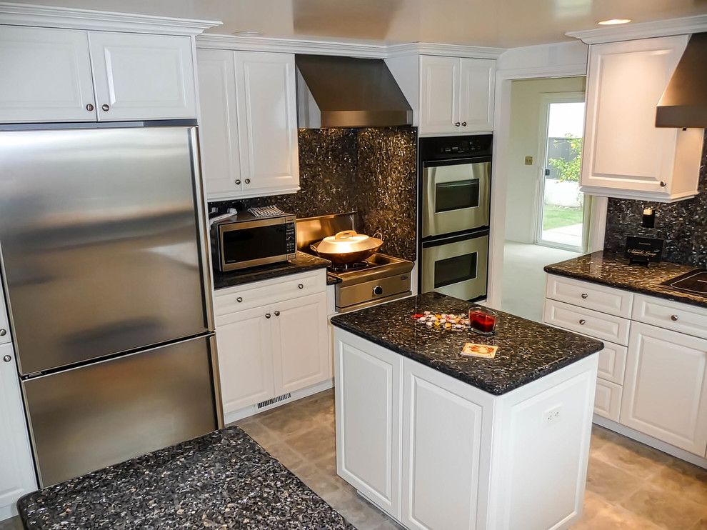 This is an example of a medium sized classic u-shaped kitchen/diner in San Diego with a submerged sink, raised-panel cabinets, white cabinets, granite worktops, stone slab splashback, stainless steel appliances, vinyl flooring and an island.