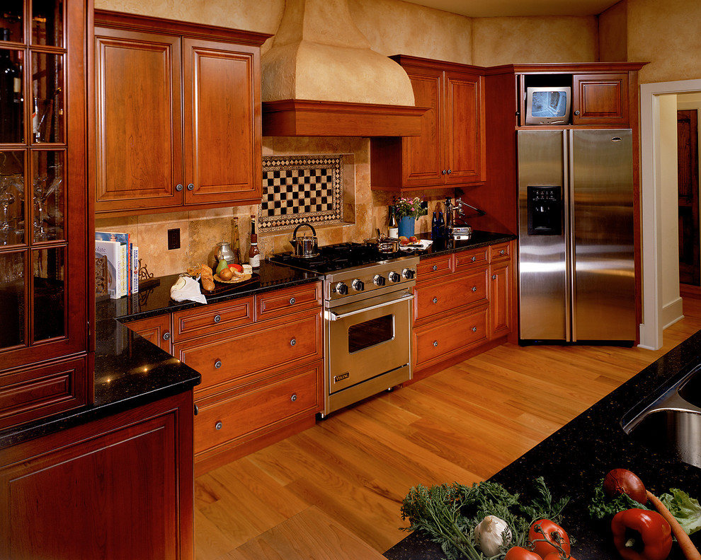 Kitchen - traditional kitchen idea in New York with an undermount sink, raised-panel cabinets, dark wood cabinets, multicolored backsplash and stainless steel appliances