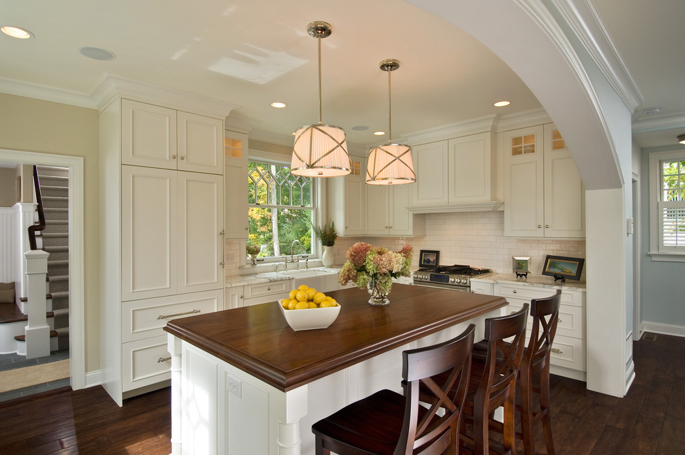 Стильный дизайн: кухня в классическом стиле с фартуком из плитки кабанчик, деревянной столешницей и барной стойкой - последний тренд