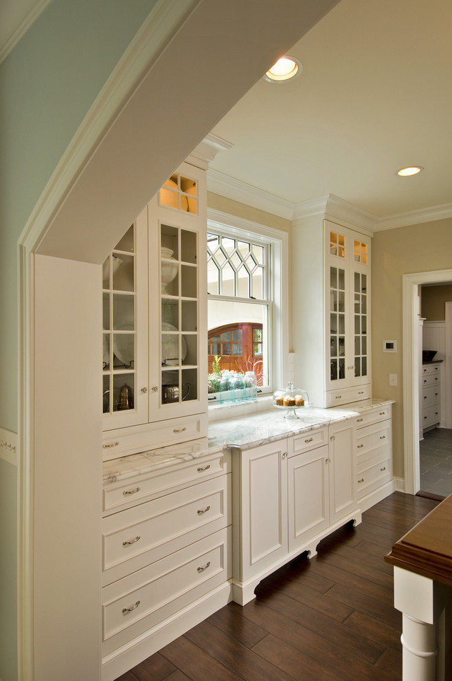 Aménagement d'une cuisine victorienne avec plan de travail en marbre et un placard avec porte à panneau encastré.