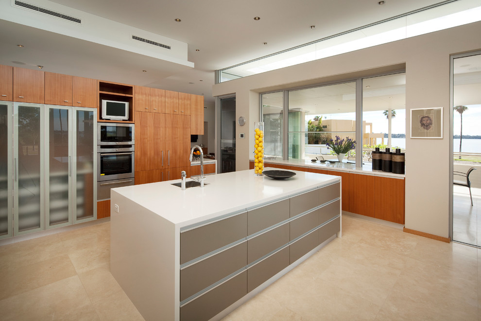 Moderne Küche mit Unterbauwaschbecken, flächenbündigen Schrankfronten, hellbraunen Holzschränken, Küchengeräten aus Edelstahl und Kücheninsel in Sonstige