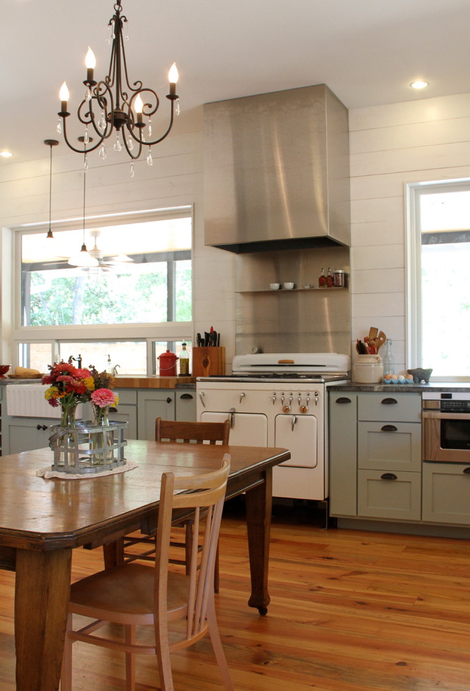 Exempel på ett mellanstort lantligt kök, med vita vitvaror, blå skåp, skåp i shakerstil, bänkskiva i täljsten, vitt stänkskydd, en rustik diskho och mellanmörkt trägolv